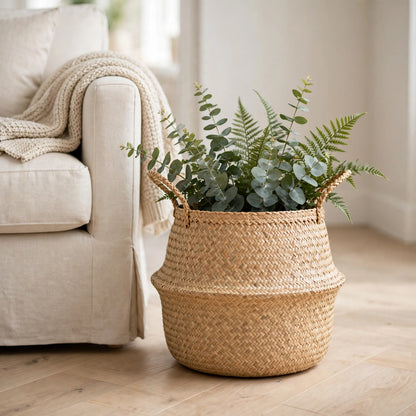 Panier en jonc de mer à pompons à côté d'un fauteuil en lin