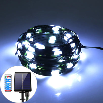 Une guirlande solaire extérieure blanche et lumineuse, alimentée par un panneau SolarSpark, émet des LED ultra-lumineuses. Elle comprend une télécommande à plusieurs boutons et est montée sur un piquet court, projetant une lumière époustouflante sur le fond sombre.