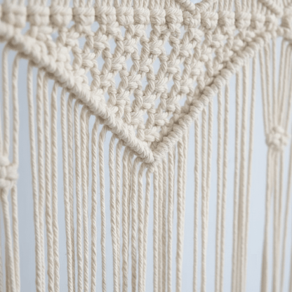 Gros plan tissage artisanal rideau en macramé coton naturel montrant texture nœuds et franges fait main