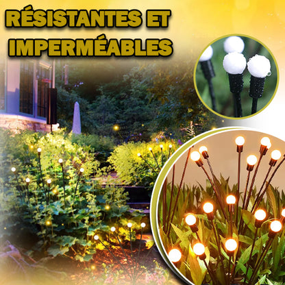Le jardin est illuminé par Lucio-Light™ de lecoledeschats, avec des lumières étanches sur des piquets au milieu dune végétation luxuriante. Le coin supérieur gauche présente « Résistantes et Imperméables », mettant laccent sur les lampes solaires jardin connues pour leur installation facile et sans fil.