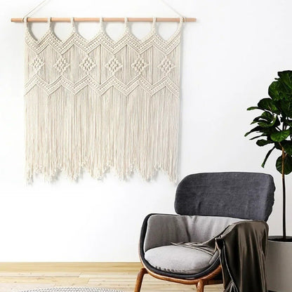 Une tenture Rideaux en macramé ivoire complexe orne un mur blanc minimaliste, apportant une touche artisanale et chaleureuse à la pièce.
La texture nouée délicate crée un motif géométrique captivant, projetant de subtiles ombres.
Suspendue à une tringle en bois clair, l'œuvre d'art encadre un fauteuil gris confortable et une plante verte luxuriante.
Ce décor mural, évoquant des "Rideaux en macramé", ajoute une ambiance bohème et raffinée à l'intérieur.