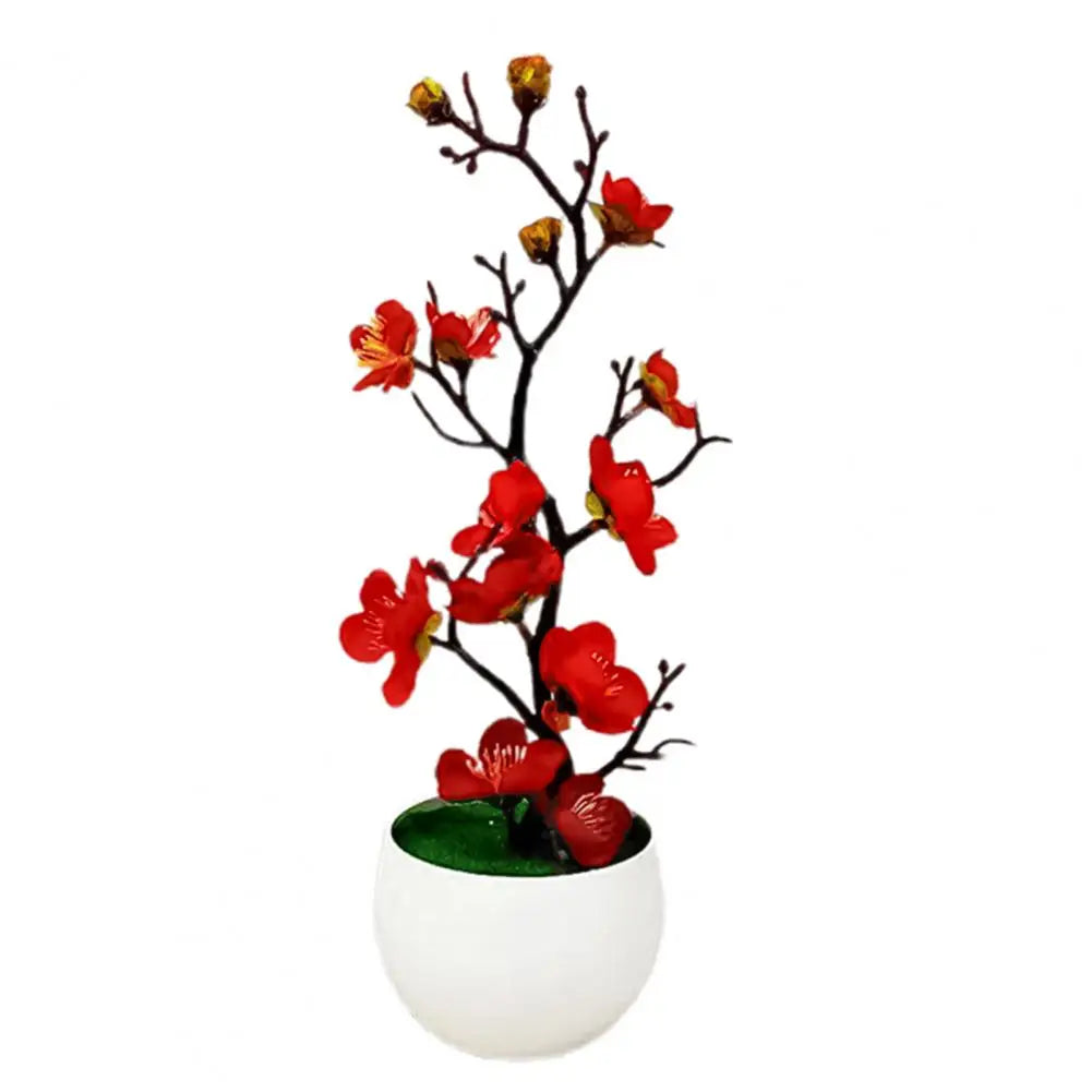 "Plante artificielle en pot blanc avec fleurs rouges."
