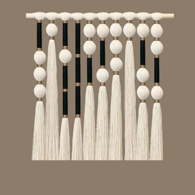 Rideau en macramé décoratif suspendu à une tringle en bois.
Des motifs de perles blanches et de sections enveloppées de fil noir créent un contraste visuel.
De longues franges de coton blanc pendent du bas, ajoutant une texture douce.
L'ensemble évoque un style bohème et artisanal pour une ambiance chaleureuse.