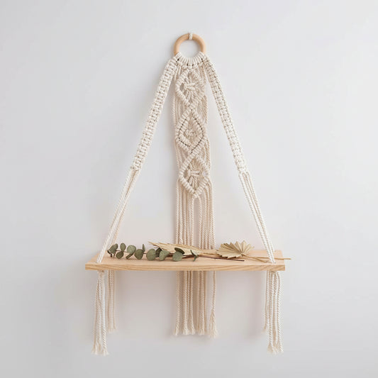 Étagère murale macramé avec plateaux bois accrochée sur mur blanc avec plantes