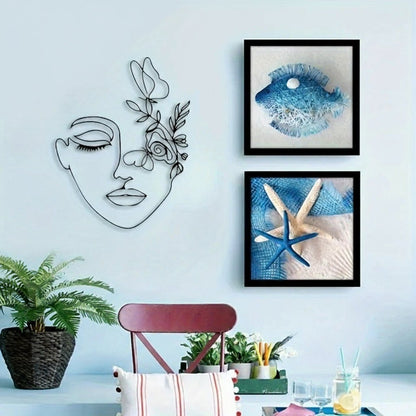 Decors murale metal visage fleuri, encadrée de tableaux marins et plante verte.